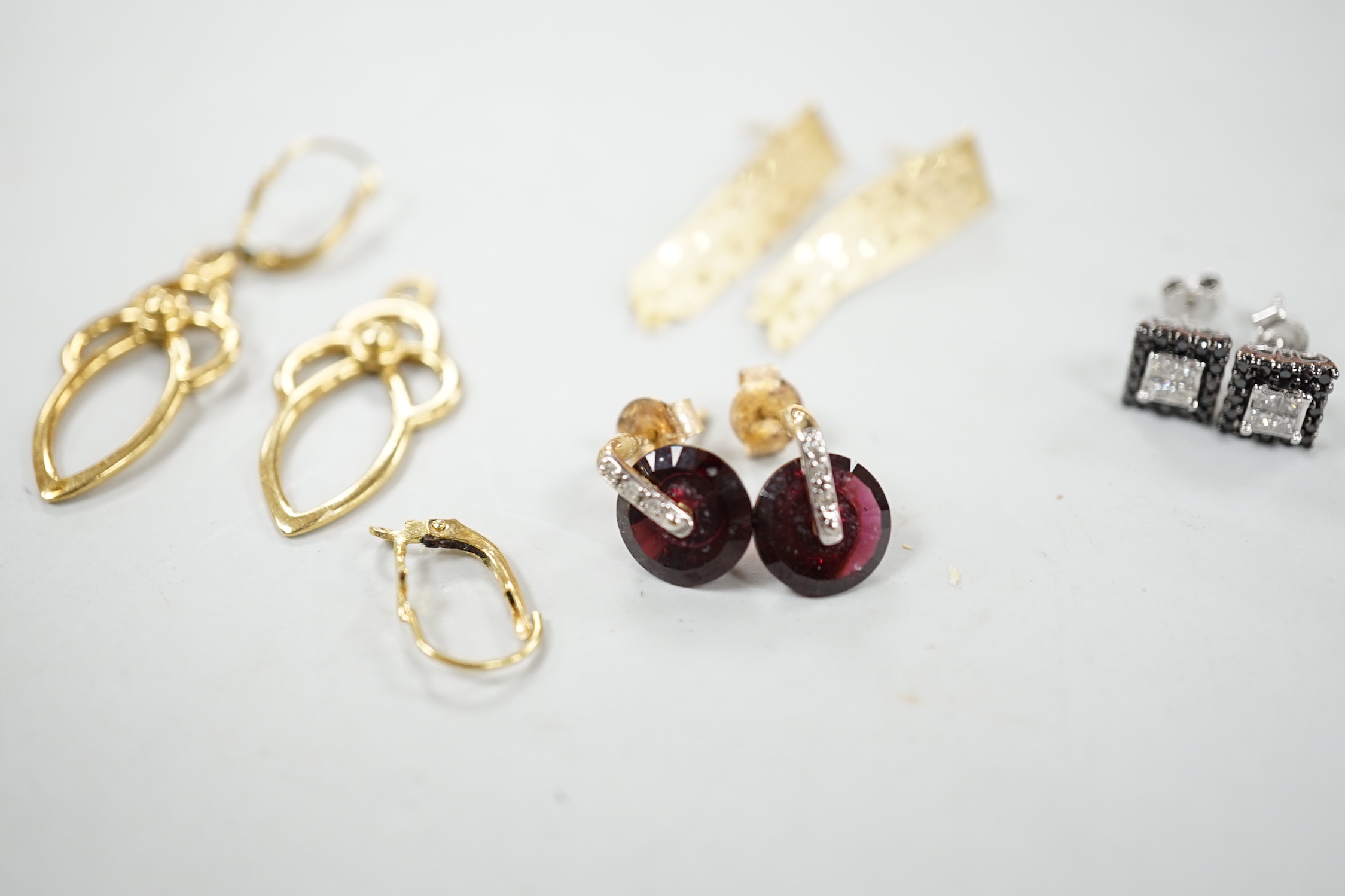 A modern pair of 18ct gold scroll drop earrings, 26mm, 4.7 grams (a.f.) and three other pairs of earrings including 10k, garnet? and diamond and 10k pave set two colour diamond.